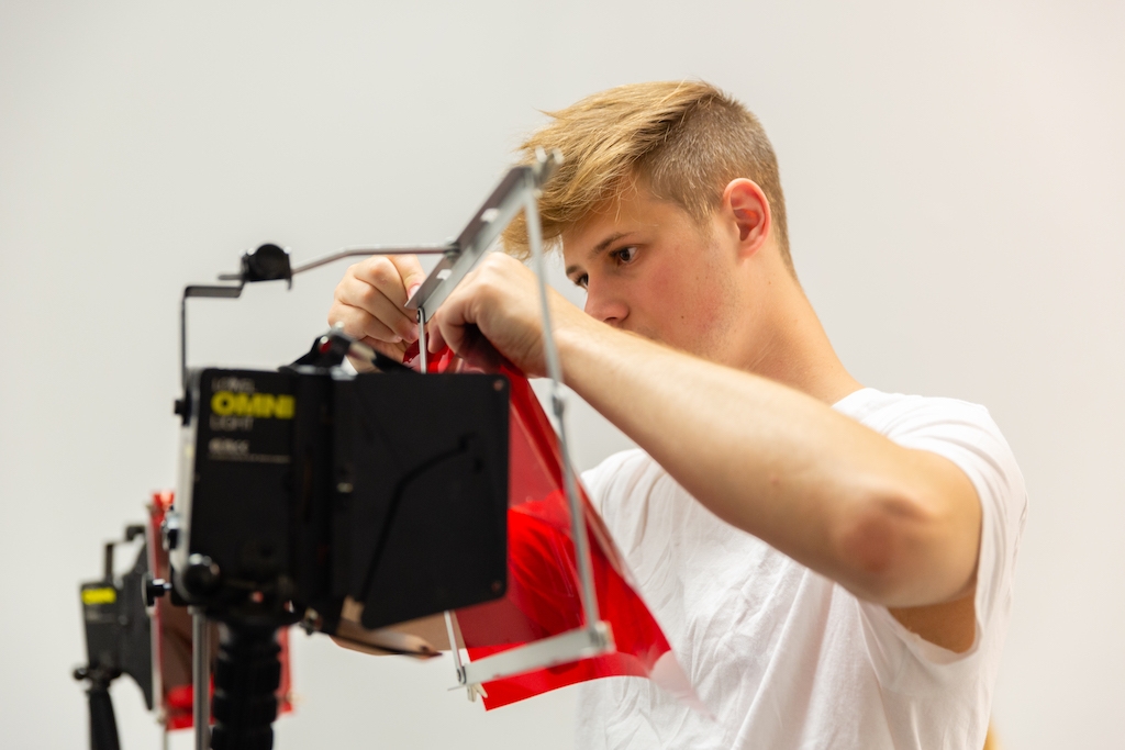 Student changing the filter in a professional film light
